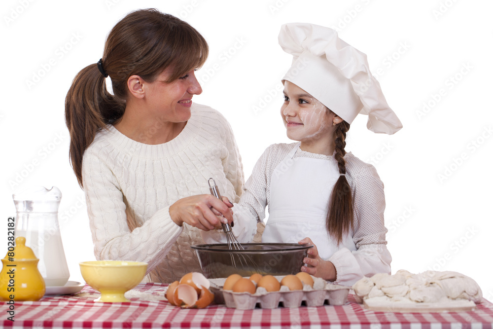 Happy mother with little daughter joyful cooking