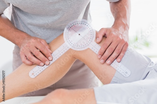 Quadro su tela Doctor examining man leg