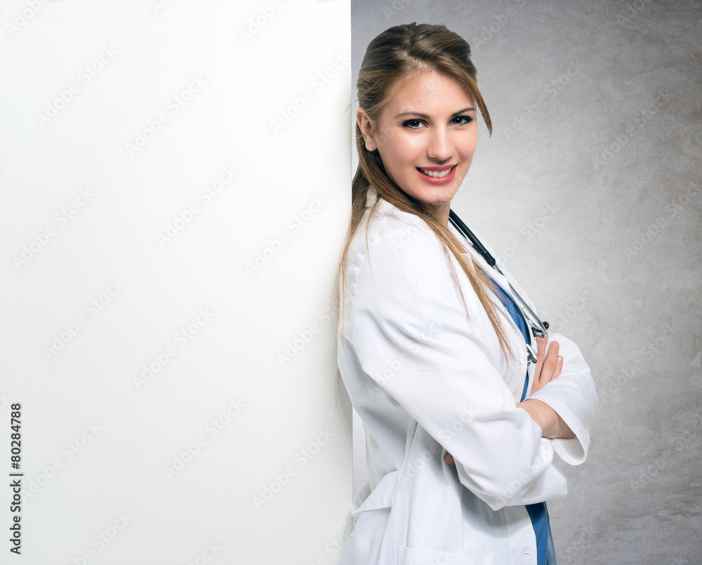 Smiling doctor leaning against a blank board Smiling doctor leaning against a blank board