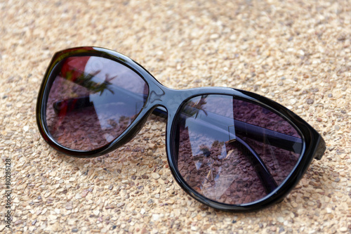 Sunglasses on sandstone floor