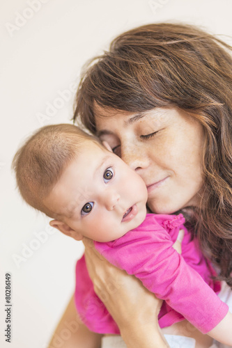 Family Concept: Portrait of Young Mother Taking Care of Her Litt