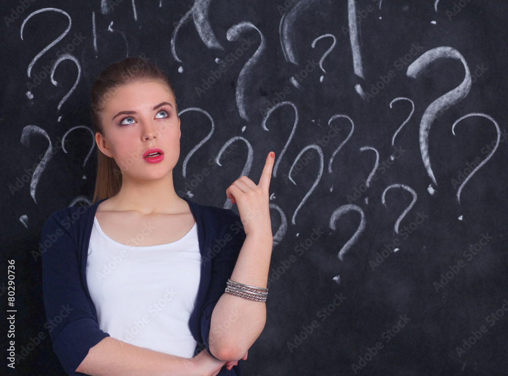 Young girl with question mark on a gray background Young girl with question mark on a gray background