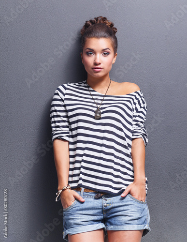 Young woman standing, isolated on gray background