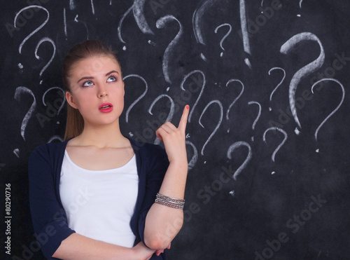 Young girl with question mark on a gray background