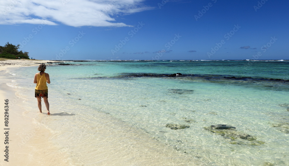 femme se promenant sur plage et lagon de l'île maurice