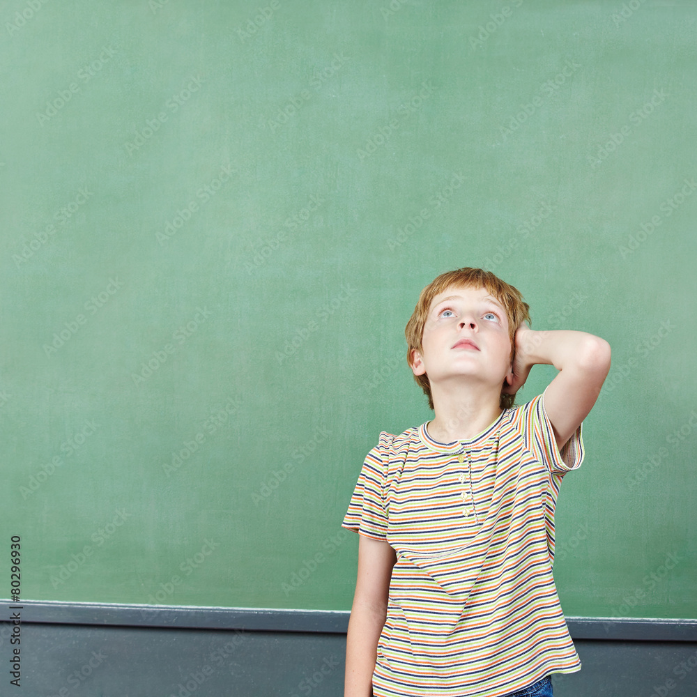 Boy standing in front of empty chalkboard Boy standing in front of empty chalkboard