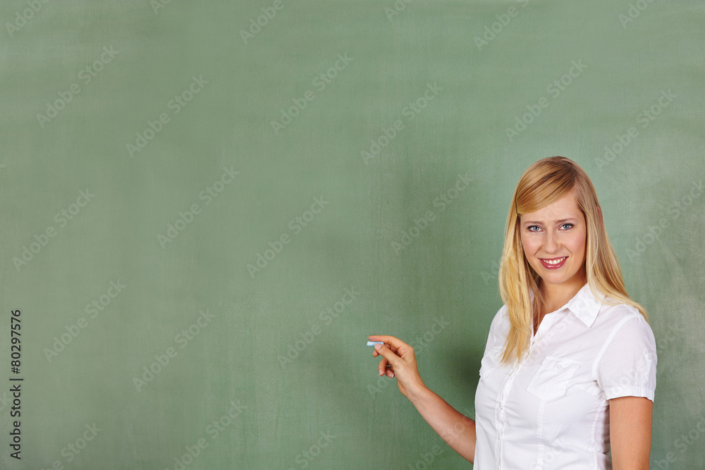 Teacher with chalk in front of chalkboard Teacher with chalk in front of chalkboard