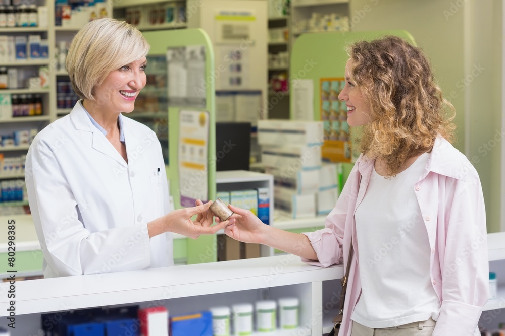 Pharmacist and costumer holding medicine jar