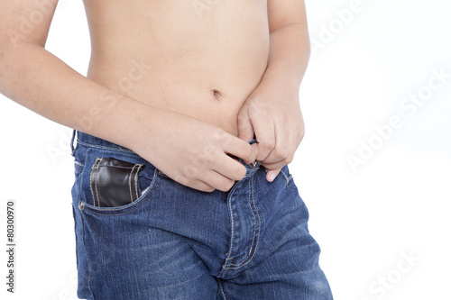 boy buttoning jeans on a white background