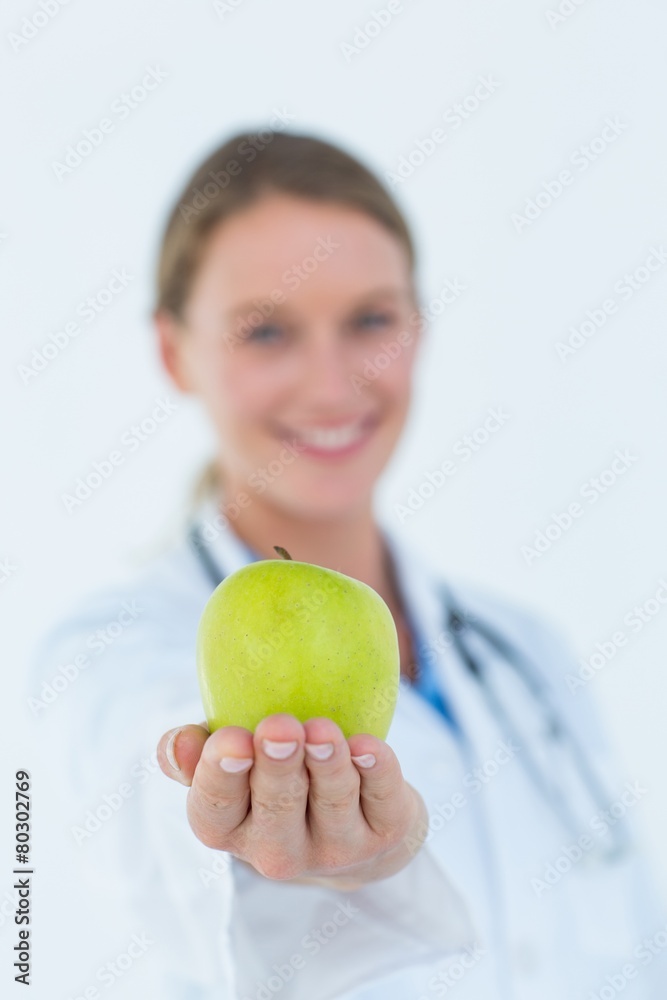 Smiling doctor offering an apple Smiling doctor offering an apple