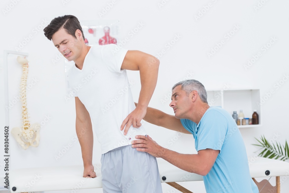 Doctor examining his patient back Doctor examining his patient back