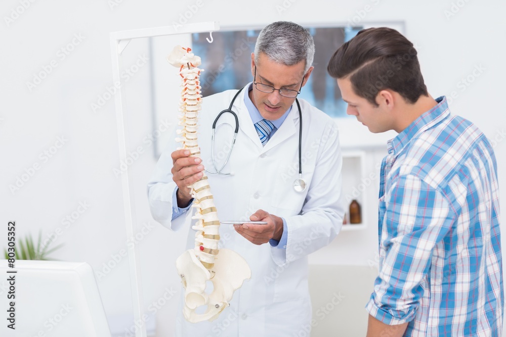 Doctor explaining the spine to his patient Doctor explaining the spine to his patient