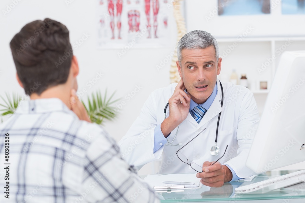 Fototapeta premium Doctor examining patient with neck ache