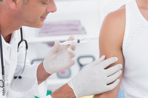 Doctor doing an injection to his patient