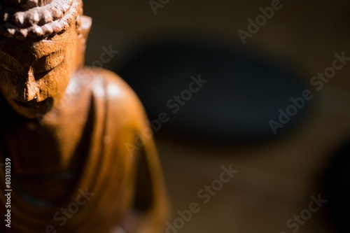 Wooden buddha statue on table Fototapeta