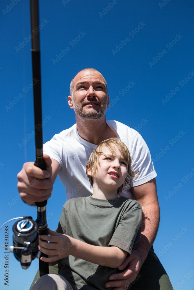 Happy man fishing with his son - obrazy, fototapety, plakaty 