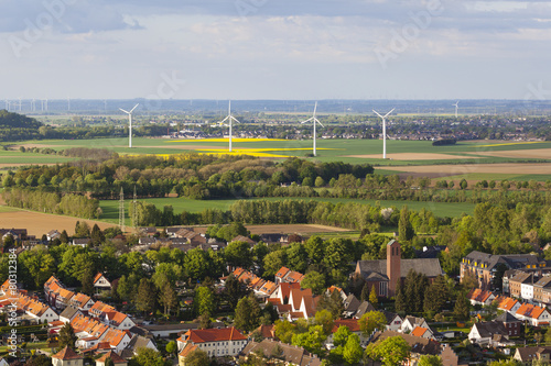 Village and wind turbines in flat landscape photo
