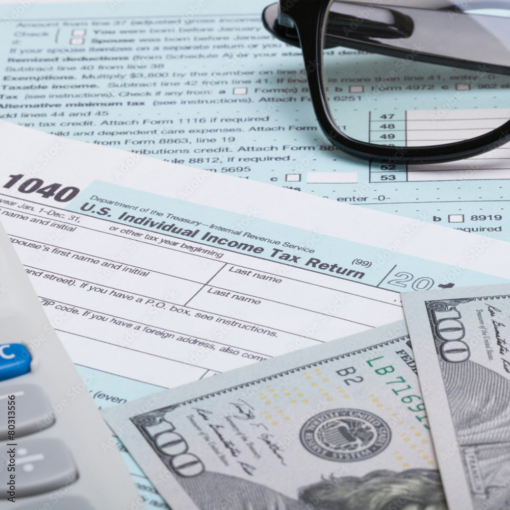 US 1040 Tax Form, calculator, glasses and dollars - studio shot US 1040 Tax Form, calculator, glasses and dollars - studio shot