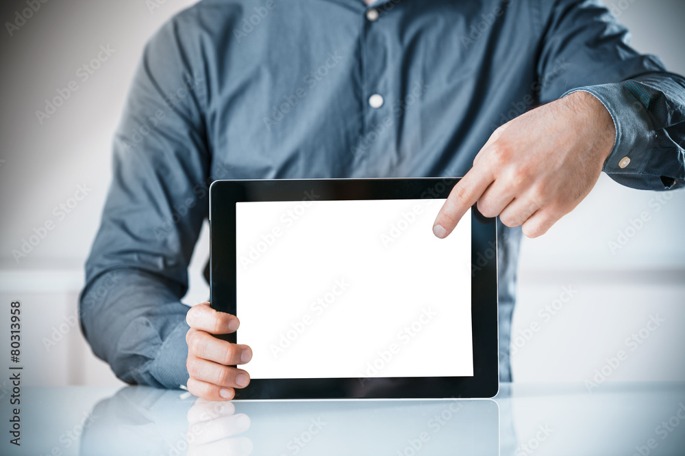 Businessman pointing to a blank screen of a tablet