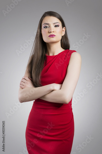 Priggish young woman with arms crossed