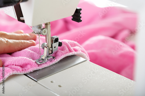 Working on sewing machine. Close look of hands and needle