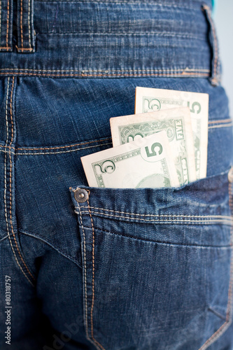 five dollars banknotes in a pocket of jeans