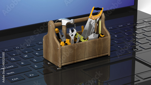 Toolkit with various tools on laptops keyboard photo