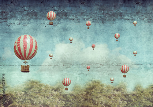 Hot air ballons flying over a forest