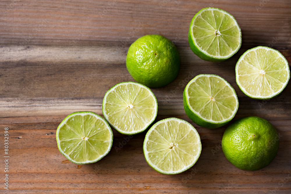 Fresh cut limes on wooden background Fresh cut limes on wooden background