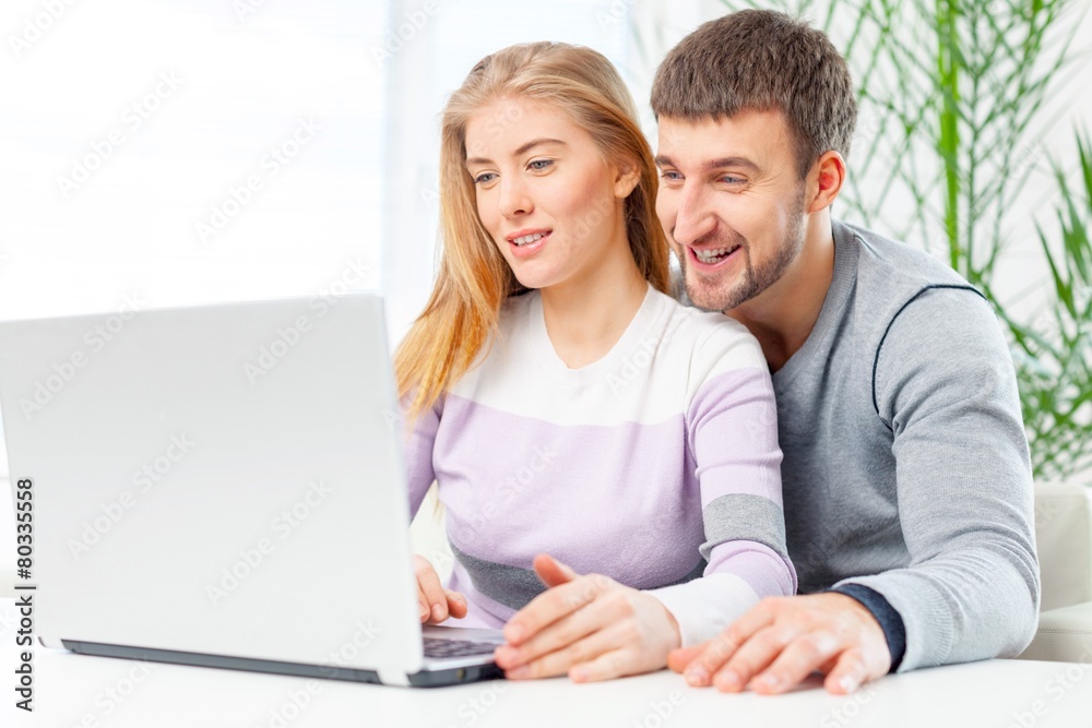 Laptop. Close up beautiful couple working on laptop at home Laptop. Close up beautiful couple working on laptop at home