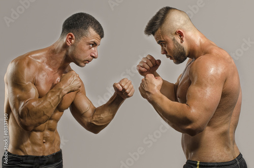 Two muscular men fighting, bodybuilders punching each other
