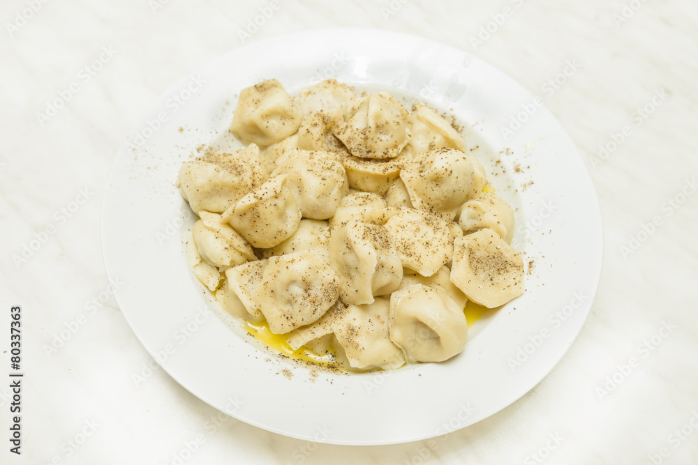 cooked pelmeni sprinkle with pepper