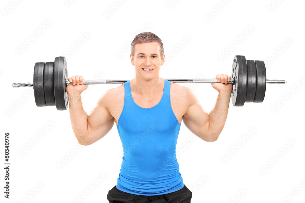 Young smiling athlete in blue shirt exercising with a heavy weig Young smiling athlete in blue shirt exercising with a heavy weig