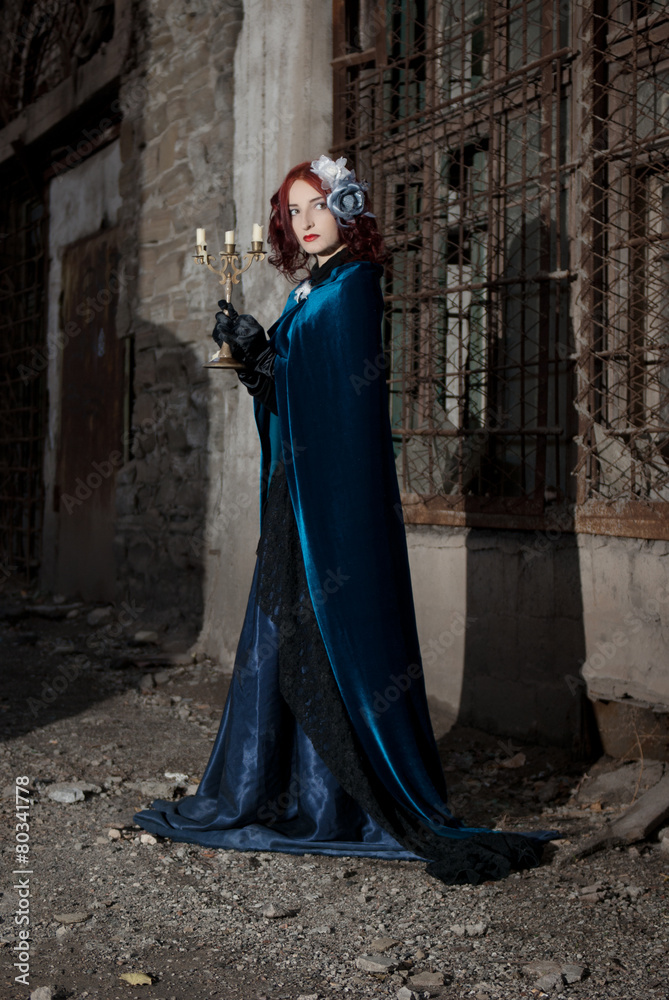 Naklejka premium Gothic redhead woman walking with candle