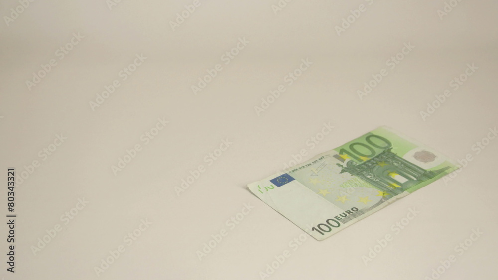 A 100 Euro bill dropping on the table A 100 Euro bill dropping on the table