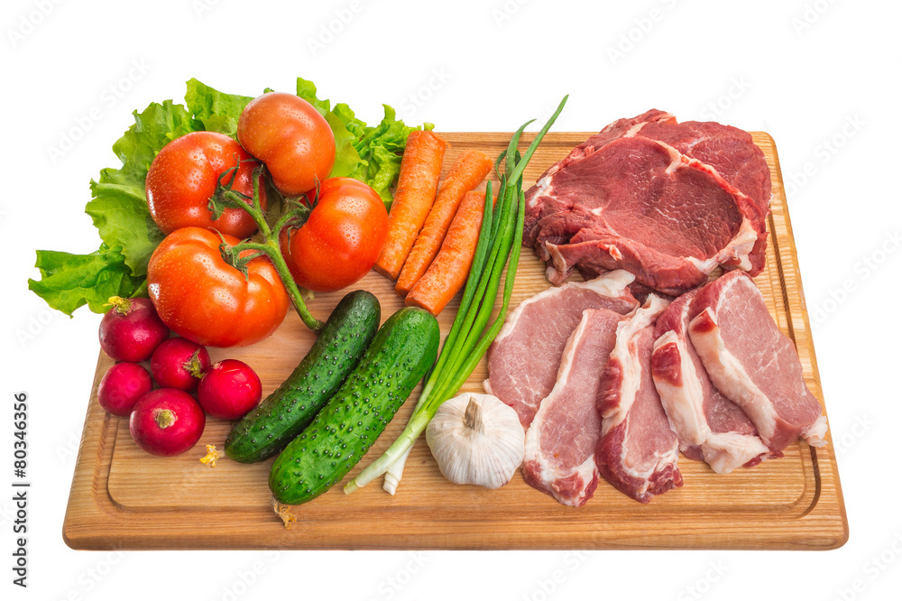 Fresh raw meat and vegetables on a cutting board
