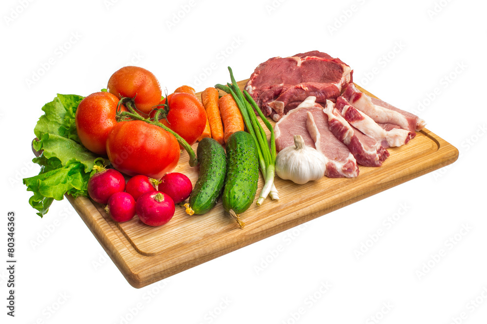 Fresh raw meat and vegetables on a cutting board Fresh raw meat and vegetables on a cutting board