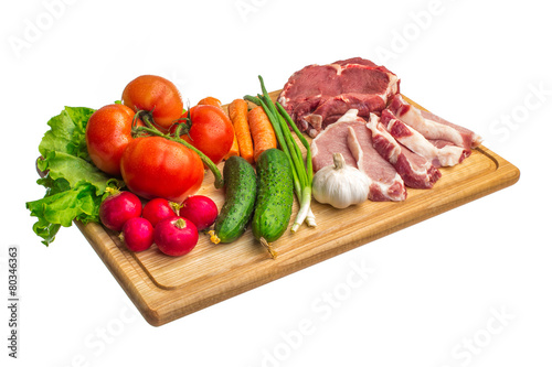 Fresh raw meat and vegetables on a cutting board