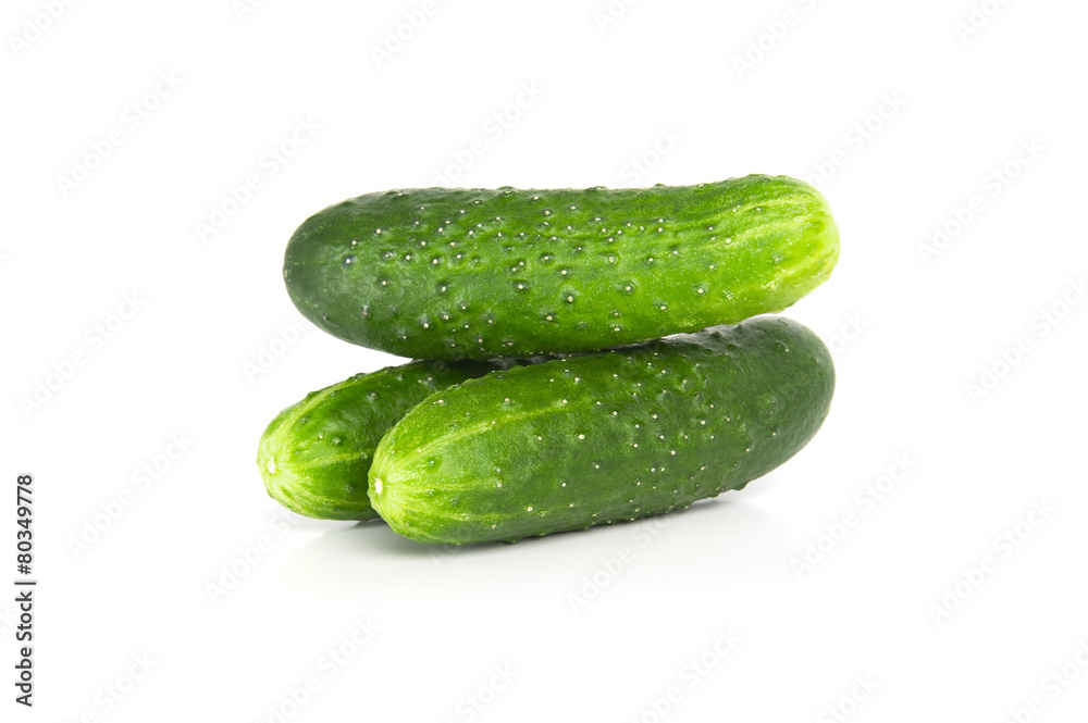 Three fresh cucumbers on a white background.. Three fresh cucumbers on a white background..