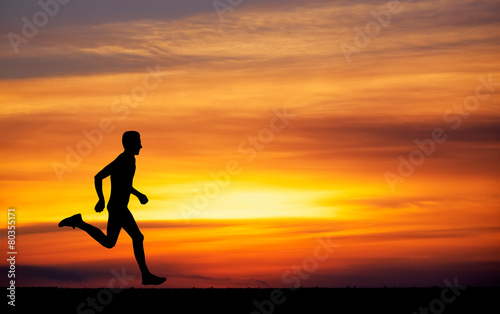 Silhouette of running man against the colorful sky.