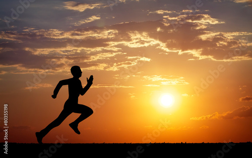 Fototapeta Naklejka Na Ścianę i Meble -  Silhouette of running man against the colorful sky.