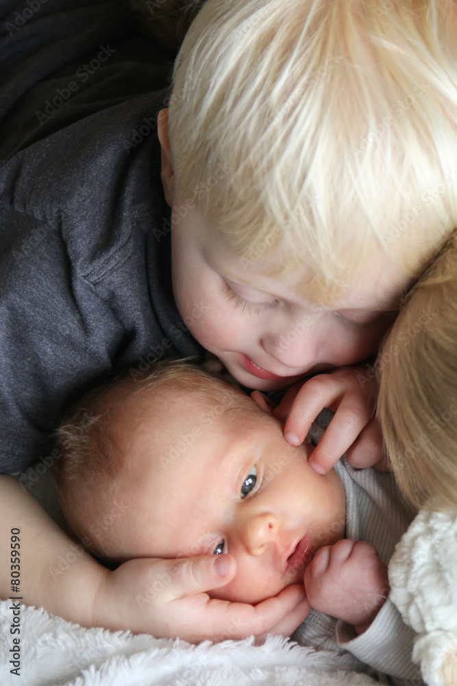 Big Brother Looking at Newborn Baby with Love Big Brother Looking at Newborn Baby with Love