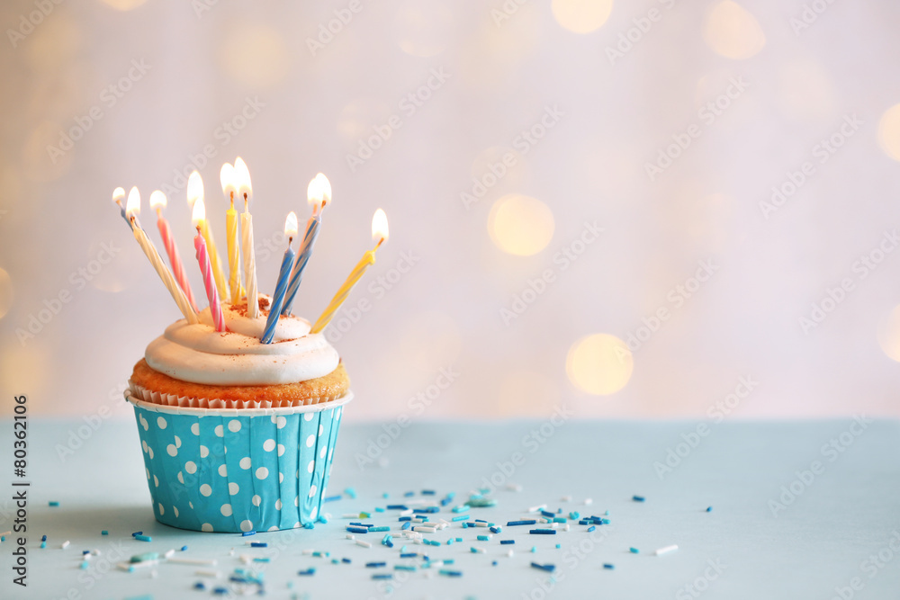Delicious birthday cupcake on table on light background - obrazy, fototapety, plakaty 