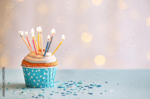 Fényképezés Delicious birthday cupcake on table on light background