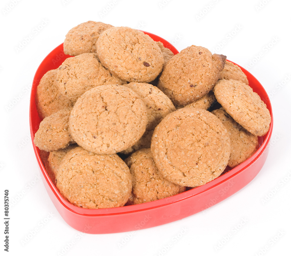 Oatmeal cookies in a red heart pot isolated on white background Oatmeal cookies in a red heart pot isolated on white background