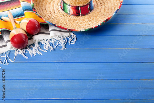 Mexican background with sombrero and traditional serape rug or blanket on old blue wood planked background Mexico fiesta cinco de mayo photo