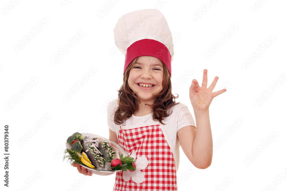 happy little girl cook with fish and ok hand sign happy little girl cook with fish and ok hand sign