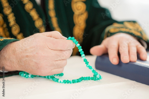 An old man's hand with rosary beads