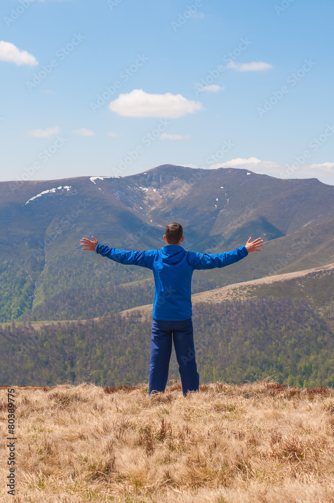 Mountaineer reaches the top of a mountain in sunny spring day. Mountaineer reaches the top of a mountain in sunny spring day.