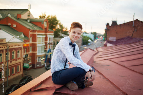 Happy hipster on the edge of the roof